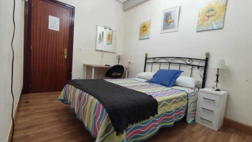 a bedroom with a bed and a desk and a chair at FlipHouse Rooms Pensión in Bilbao