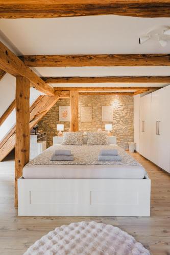 a bedroom with two beds in a room with wooden ceilings at Hostellerie des Princes-Evêques - Le Donjon in Porrentruy