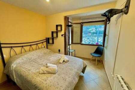 a bedroom with a bed with two towels on it at Kai Etxea , el mismo puerto de Bermeo in Bermeo