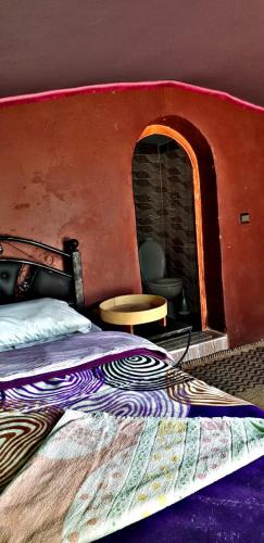 a bedroom with a bed with a brick fireplace at Camp sahara in Oulad Akkou