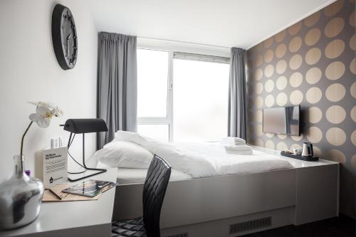 um quarto com uma cama, uma escrivaninha e uma janela em Stravinsky Slapen em Hengelo