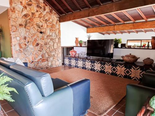 a living room with a couch and a stone wall at Residência hoteleira Aldeia da Praia Guarapari in Guarapari