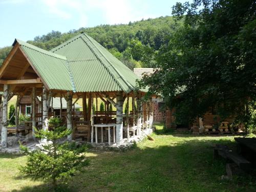 a pavilion with a green roof in a yard at Staparski Sorrento in Užice