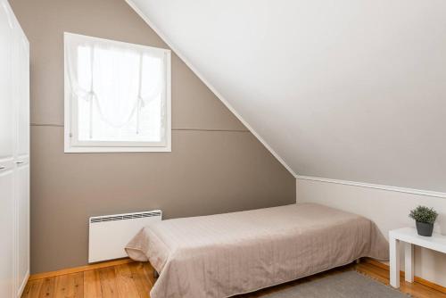 a bedroom with a bed and a window at CYV - A unique Villa on a Lake in Karhoinen