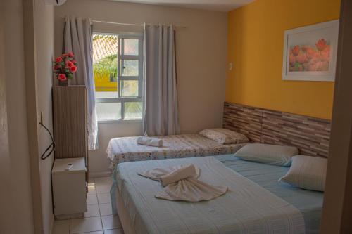 Un dormitorio con dos camas y una ventana en Ponta Negra_Apto Completo, en Natal