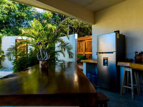 a kitchen with a table and a refrigerator at Villa Privada Merkaba Pxm in Brisas de Zicatela