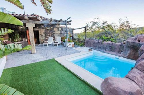 a backyard with a swimming pool and a house at Casa Oronado in Ingenio