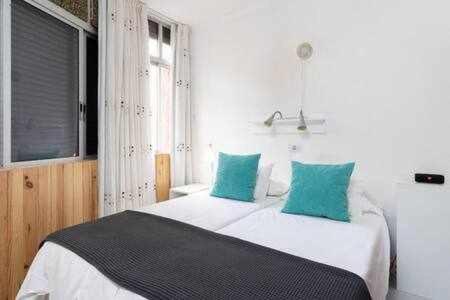 a bedroom with a large bed with green pillows at Apartamento Playa San Juan WIFI in Playa de San Juan