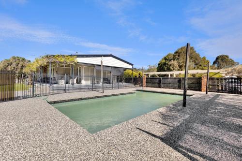 a swimming pool in front of a house at Chenu Lakeside Homestead in Eagle Point