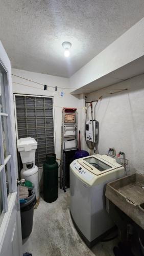 a kitchen with a sink and a toilet in a room at El Arrecife: Apartamento con alberca a 10 minutos de la playa in Acapulco