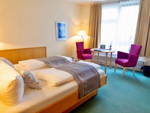 a hotel room with a bed and a table and chairs at Schlosshotel Eyba in Saalfeld