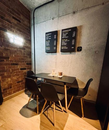 a table and chairs in a room with a brick wall at Travel VIP Lounge Themed Stay with Private Parking in Monterrey