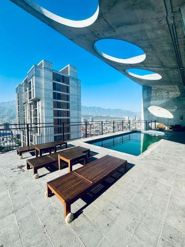 a patio with benches and a pool on a building at Travel VIP Lounge Themed Stay with Private Parking in Monterrey