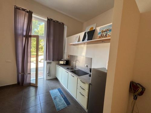 a small kitchen with a sink and a window at Casa in Pineta in Follonica