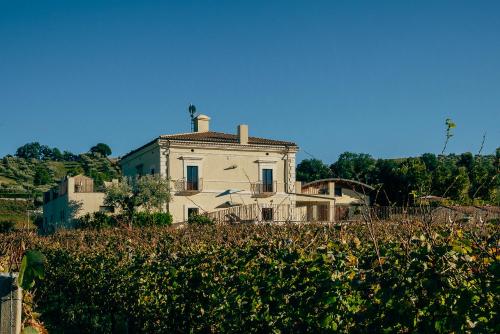 an old house on a hill with a field of crops at Baldovino b&b in Villamagna