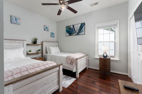 une chambre avec deux lits et un ventilateur de plafond dans l'établissement Tranquility Oasis Ironman Special This Weekend, à Wilmington