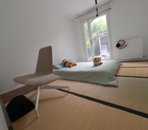 a room with a bed with a chair and a window at Chambre privée chez l habitant Jardin et Transats in Noisy-le-Sec