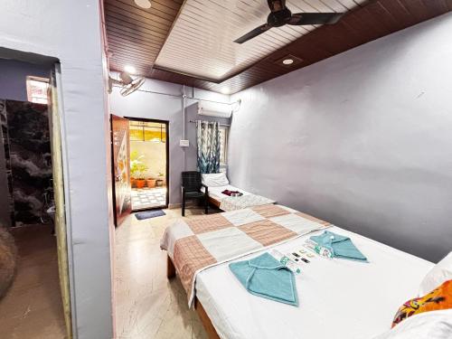 a bedroom with two beds and a room with a window at Reddy home stay in Hampi