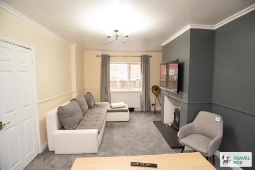 a living room with a couch and a tv at Sherwood Pines - Big Garden! in Clipstone