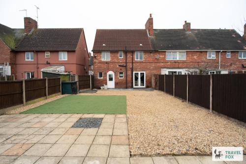 a yard with a fence and two houses at Sherwood Pines - Big Garden! in Clipstone