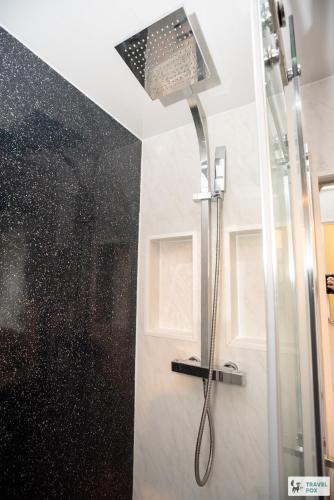 a shower with a shower head in a bathroom at Sherwood Pines - Big Garden! in Clipstone