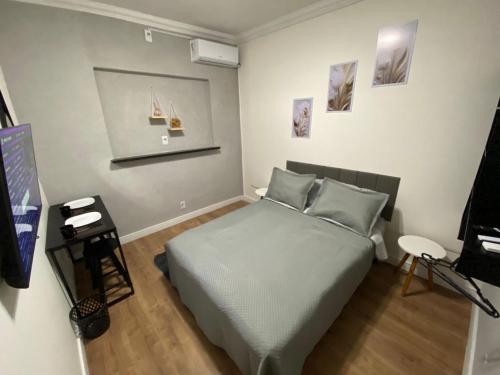 a bedroom with a bed and a flat screen tv at Apartamento compartilhado em Guarapuava - Quarto 2 in Guarapuava