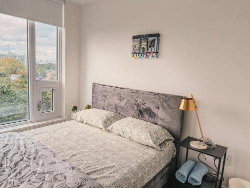 a bed in a bedroom with a large window at LuxCondo in the Downtown Kitchener Uptown Waterloo in Kitchener
