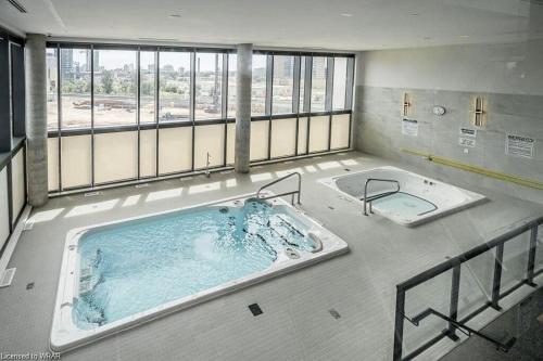 a large bath tub in a room with a large window at LuxCondo in the Downtown Kitchener Uptown Waterloo in Kitchener