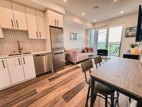 a kitchen and living room with a table and a kitchen at LuxCondo in the Downtown Kitchener Uptown Waterloo in Kitchener