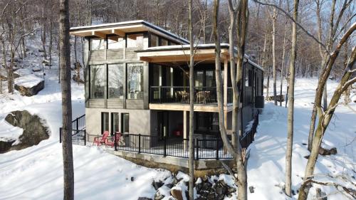 a house in the woods in the snow at Twin Cottages with Mountain & Lake View in Morin Heights