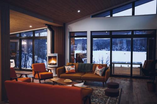 a living room with a couch and a fireplace at Twin Cottages with Mountain & Lake View in Sainte-Adèle