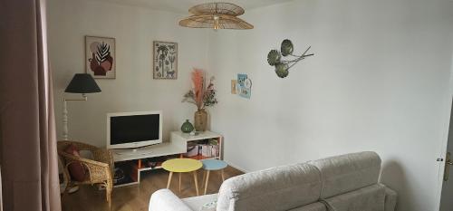 a living room with a couch and a television at Au coeur de Dieppe, au puits salé BY HOLIDIEPPE in Dieppe