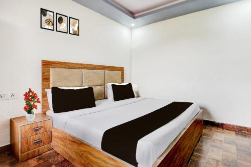 Un dormitorio con una cama grande y un jarrón de flores. en Hotel O DIAMOND INN, en Nueva Delhi