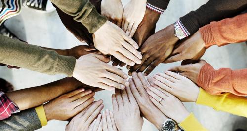 a group of people putting their hands together in a circle at Trinidad near port of spain in Port-of-Spain