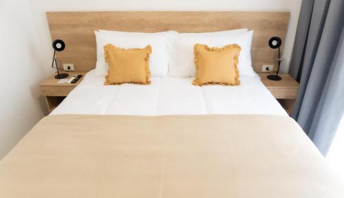 カンパーナにあるRM Campana Hotelの白いベッドと枕が2つある寝室
