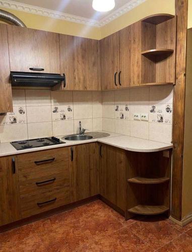a kitchen with wooden cabinets and a sink at Підгорянка in Yaremche