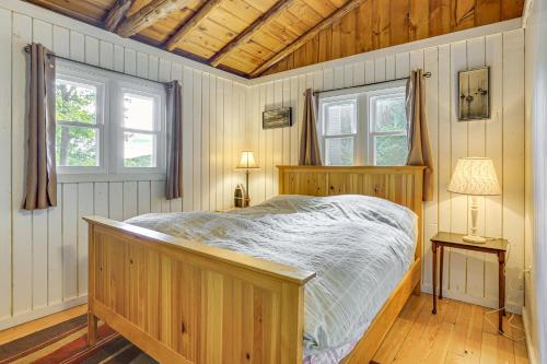 a bedroom with a wooden bed and two windows at Boat, Hike and Fish Rustic Greenwood Retreat in Arlington