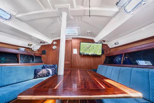 イスラ・ムヘーレスにあるStay for one night! Live on board experienceのダイニングルーム(木製テーブル、テレビ付)