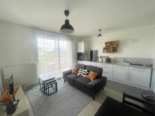 een woonkamer met een bank en een keuken bij Le 41a in Chartres