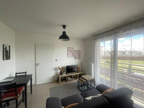 een woonkamer met een bank en een tafel bij Le 41a in Chartres