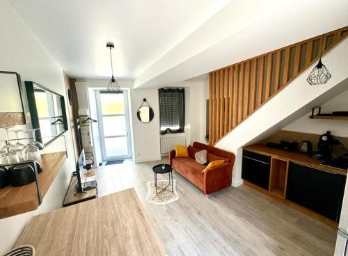 Una sala de estar con un sofá y una escalera. en Maison Lyloni Méral, en Méral