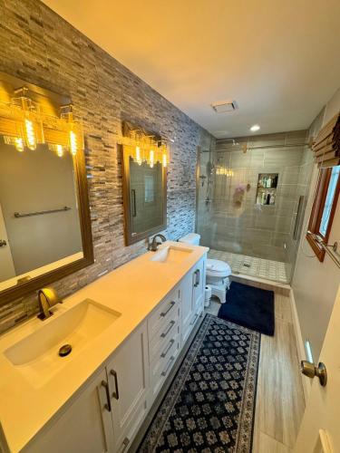 a bathroom with a sink and a toilet and a mirror at Cozy & Spacious Michigan Retreat in Livonia