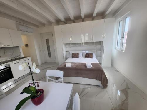 a white bedroom with a bed and a table at Residence Jasmin 2P B in Turate