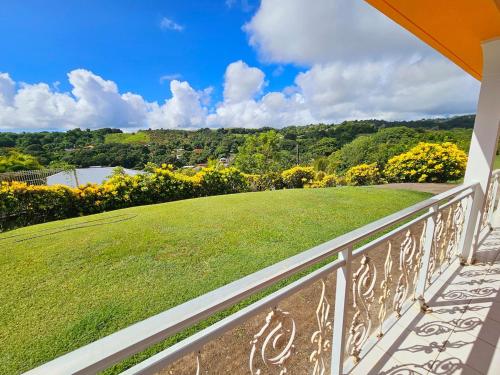 Elle comprend un balcon offrant une vue sur une cour verdoyante. dans l'établissement Exceptional villa KODEÏA - private spa & panoramic view, à Sainte-Marie