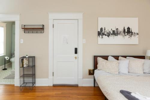 a bedroom with a bed with white walls at Sunny efficiency in historic home in Durham