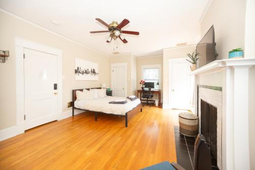 a living room with a ceiling fan and a fireplace at Sunny Efficiency In Historic Home in Durham