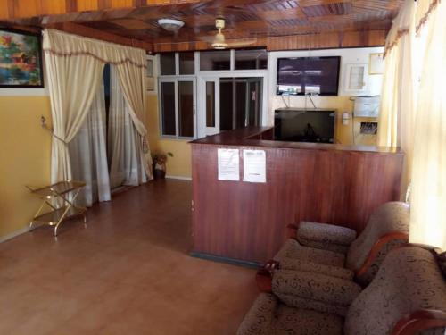 a living room with chairs and a podium with a tv at Heritage Hotel in Trofwi