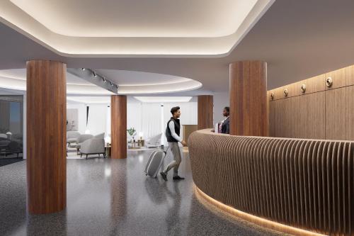 a woman walking through an office lobby at Sercotel HMO Martina in Granada