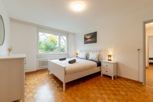 a bedroom with a white bed and a window at Swiss Suites Oberrohrdorf in Rohrdorf