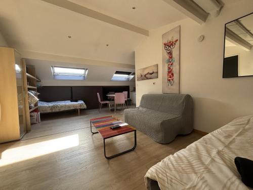 a living room with a couch and a table at Studio 4 personnes 3 lits Thionville Wifi Parking in Thionville